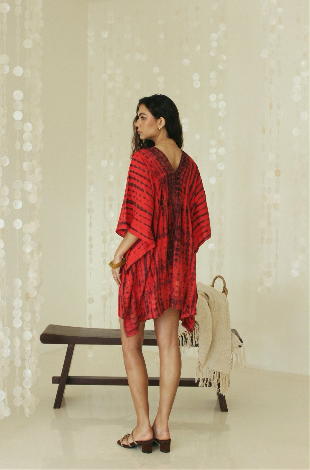 Back view of a red Bali tie-dye mini kaftan dress designed for effortless resort wear - Tulalara